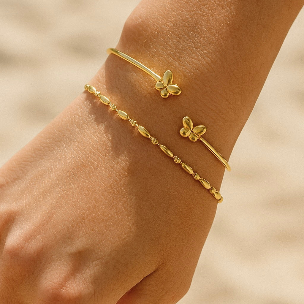 DIVINE Butterfly Gold Cuff worn on wrist, adjustable 18K gold PVD stainless steel cuff with twin butterfly detail – CCaura