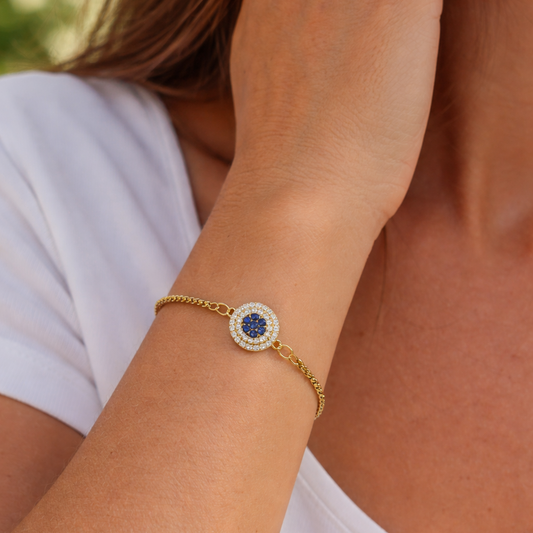 MIRA Charm Gold Bracelet worn on wrist, adjustable 18K gold PVD bracelet with crystal and blue detail charm – CCaur