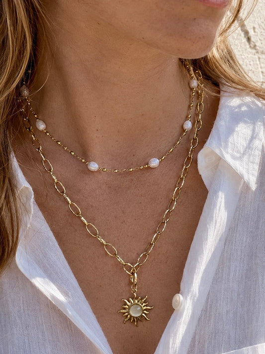 Double necklace - Freshwater pearl and Gold sun pendant necklace wearing a white linen shirt