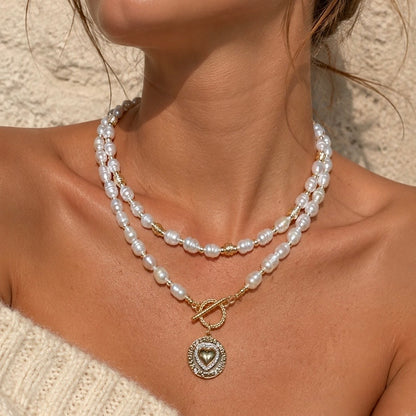 ISLA PEARL NECKLACE freshwater pearls, gold coin pendant and gold toggle clasp, layered with another necklace, worn by model — CCaura 