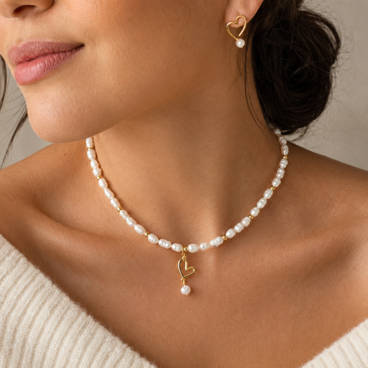 CELESTE PEARL HEART NECKLACE - 18K Gold PVD beads and freshwater pearls necklace with a hanging gold heart charm and pearl drop, worn by model with matching earrings.CCAura