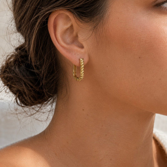 JUNO TEXTURED GOLD HUGGIES gold earrings CCaura white background
