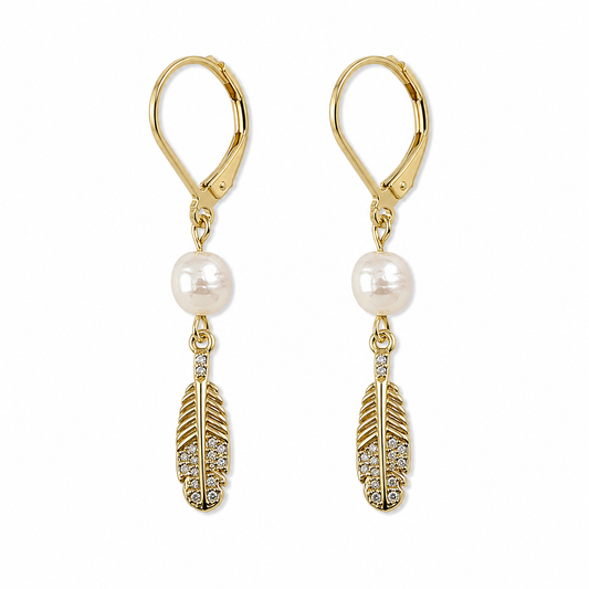 MARINA FEATHER PEARL EARRINGS 18K Gold PVD and freshwater pearls with hanging gold feather, cubic zirconia detailing -on white background. CCAura