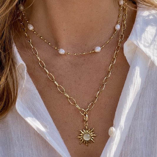 SANTORINI SUN LAYERED NECKLACE - 18K gold PVD plated paperclip chain, freshwater pearl and gold bead chain and sun pendant. Worn by model CCAura