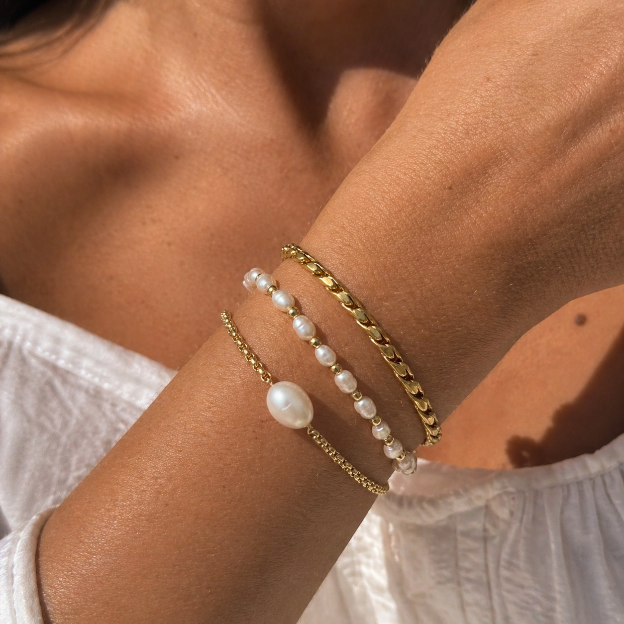 HESTIA Pearl Bracelet stacked with gold bracelet and a pearl bracelet, worned by model – CCaura
